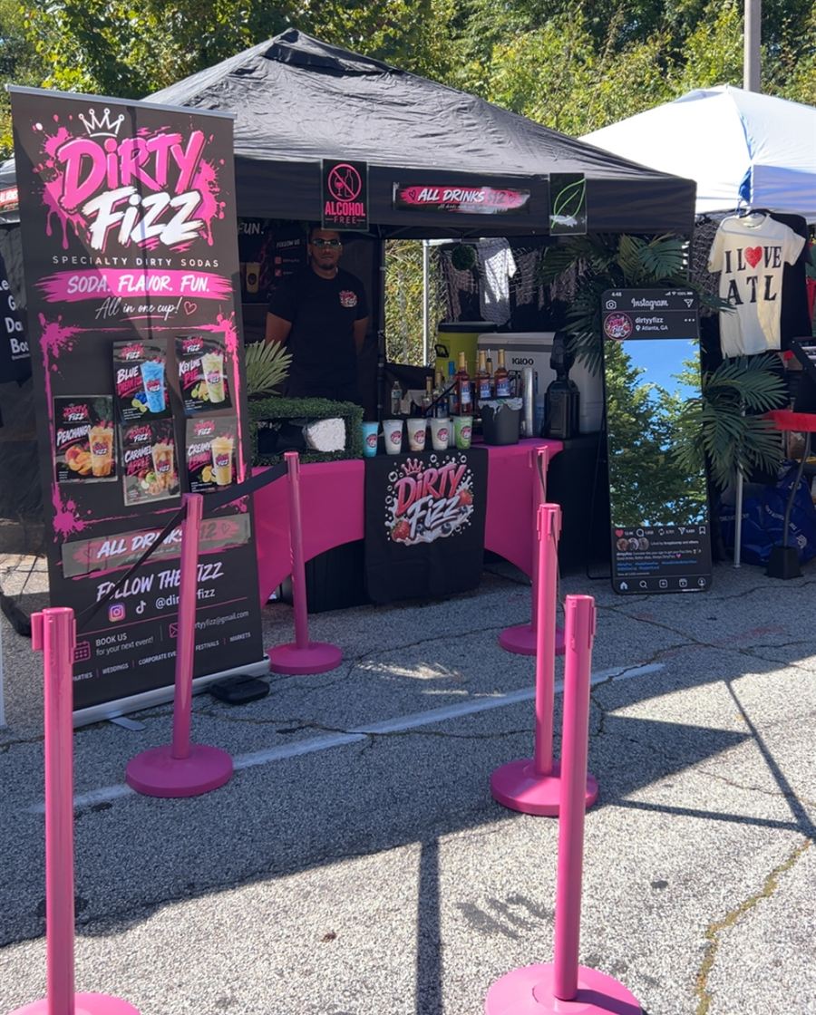 Dirty Fizz banner and pink line stanchions at a street festival